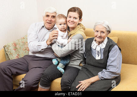 Quatre génération family sitting on sofa at home Banque D'Images