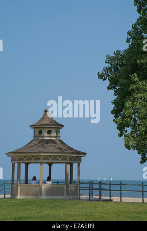 Rochester, New York, en Ontario. Deux femmes à la recherche sur le lac Ontario et voiliers de park gazebo sur calme journée d'été. Banque D'Images