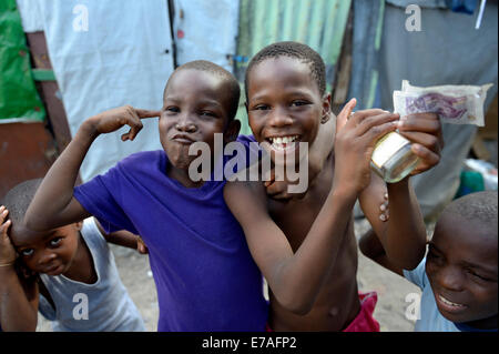 Deux garçons posant avec de l'argent, l'alcool et le geste d'une arme à feu, les gestes pour les idoles des enfants, Camp d'Icare pour Banque D'Images