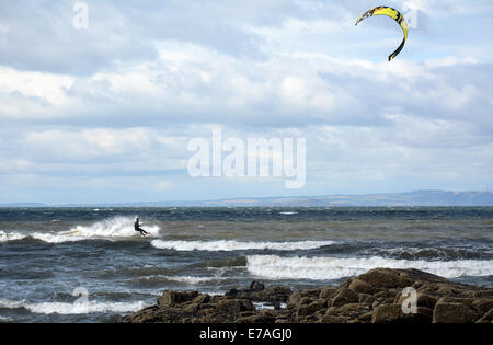 Un kite surfer exploite au maximum les forts vents et le soleil. Banque D'Images