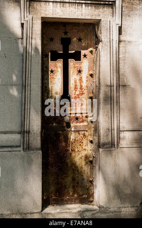 Un fer rouillé porte mausolée dans un cimetière de Paris France. Banque D'Images