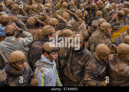 Hommes et garçons musulmans chiites, couvert de boue, le chant et l'auto-flagellating pendant Ashoura, dans Bijar, Iran. Banque D'Images