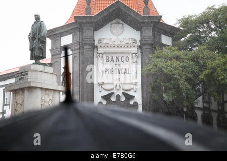 Banco de Portugal, Funchal, Madère au cours d'une douche à effet pluie. un parapluie peut être vu dans l'avant-plan Banque D'Images