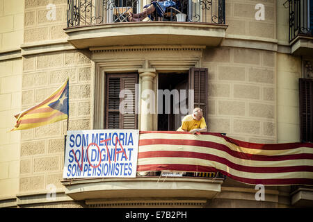 Barcelone, Espagne. Sep 11, 2014. Un retraité sur son balcon donne sur des milliers de Catalans en rouge et jaune shirts protestent contre la tenue d'un référendum dans la Gran Via de Barcelone sur la Catalogne, la fête nationale. Credit : ZUMA Press, Inc./Alamy Live News Banque D'Images