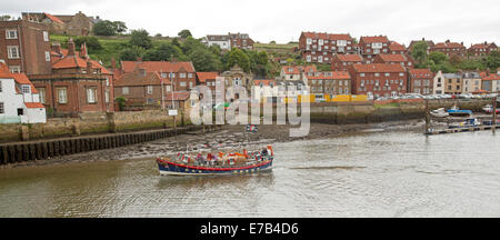 Excursion en bateau croisière à travers le port de Whitby avec des bâtiments de mer maison de ville anglais regroupés le long du front de mer Banque D'Images