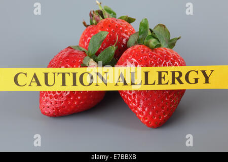 L'allergie aux fraises concept. Papier jaune avec les mots "ATTENTION" sur l'allergie à la fraise. Banque D'Images