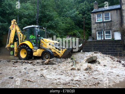 Digger inondation de compensation les débris d'une route à Hebden Bridge, West Yorkshire, Royaume-Uni Banque D'Images