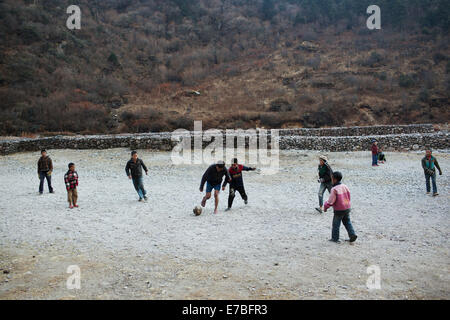 Enfants jouant au football dans la vallée de Rowling. Banque D'Images