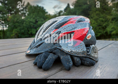 Tachés de boue casque de vélo, lunettes et gants. Banque D'Images