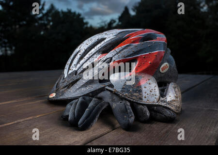 Tachés de boue casque de vélo, lunettes et gants. Banque D'Images