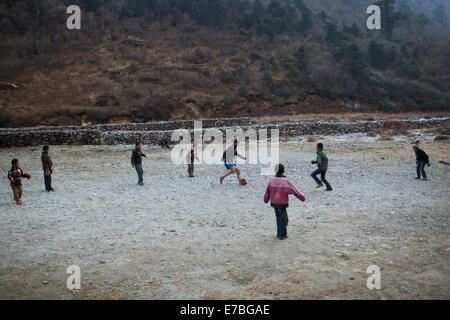 Enfants jouant au football dans la vallée de Rowling. Banque D'Images