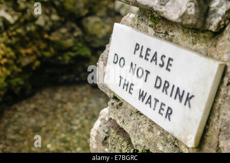 Inscrivez-pèlerins d'avertissement de ne pas boire l'eau d'un puits sacré. Banque D'Images