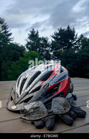 Tachés de boue casque de vélo, lunettes et gants. Banque D'Images