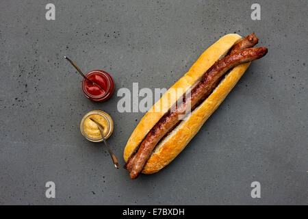 Hot dog classique moderne avec des saucisses d'agneau, bun, ketchup, moutarde sur table béton