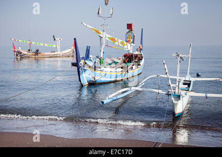 Trois bateaux de pêche ancrés à la Ceiba à Bali. et traditionnels bateaux de pêche colorés flottant au large d'une plage de Bali dans la mer. Joli seascape Banque D'Images