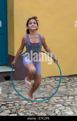 Young Girl Playing with hula hoop, Trinidad, Cuba Banque D'Images