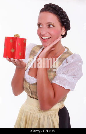 Belle femme en dirndl avec cadeau de Noël dans la main Banque D'Images