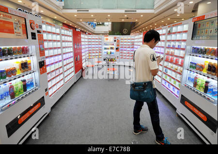 Qingdao, Chine, la province de Shandong. 13 Sep, 2014. Un client reçoit son smartphone prêt pour QR code de paiement dans un supermarché à Qingdao, province de Shandong en Chine orientale, le 13 septembre 2014. Le supermarché est constitué uniquement de la vente au détail auto automatiques qui acceptent les paiements par auto-assistés des billets de banque, de pièces ou d'intervention rapide (QR codes). © Wang Haibin/Xinhua/Alamy Live News Banque D'Images