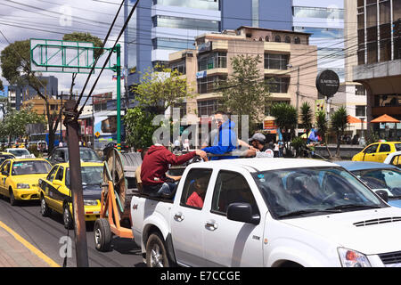 Des personnes non identifiées dans le lit d'une camionnette sur l'Avenue Amazonas, le 4 août 2014 à Quito, Equateur Banque D'Images