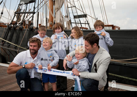 Iain Percy et Matt Baker posent avec des enfants devant le Phoenix à la Southampton Boat Show 2014 Banque D'Images