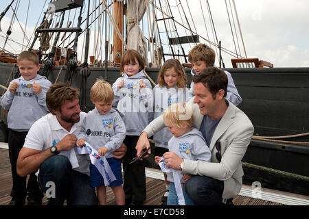 Ain Percy et Matt Baker posent avec des enfants devant le Phoenix à la Southampton Boat Show 2014 Banque D'Images