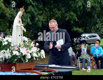Fallowfield, Manchester, UK 13 septembre 2014 Fr Simon Stamp, un jeune prêtre de Accrington, médailles bénit de Notre Dame. La Légion de Marie tient sa 41e assemblée annuelle Croisade du Rosaire dans Platt Fields Park. Une soixantaine de catholiques romains, à réciter le rosaire, chanter des hymnes et d'avoir une petite procession. Croisade du Rosaire Manchester, UK Banque D'Images