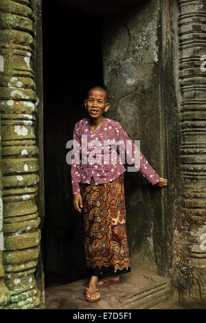 Nun à la porte d'un lieu de culte à Ta Phrom, partie d'Angkor Wat, au cours de la saison de mousson, à Siem Reap, Cambodge. Banque D'Images