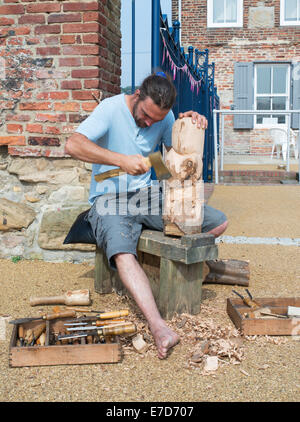 Sculpteur Mark Crowley en utilisant une hache pour découper un Dolly de proue en bois ou North Shields, North East, England, UK Banque D'Images