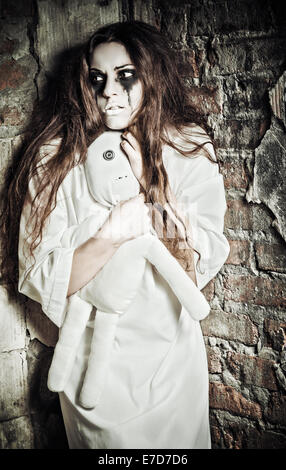 Scène d'horreur : l'étrange fille fou avec moppet poupée dans les mains Banque D'Images