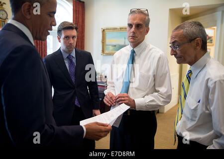 Le président américain Barack Obama parle avec les conseillers dans le bureau ovale extérieure avant de remettre une déclaration sur l'accident de Malaysia Airlines Flight 17 et la situation en Ukraine, le 18 juillet 2014 à Washington, DC. Avec le président de gauche sont Secrétaire de presse Josh Earnest, Chef de cabinet Denis McDonough et John Podesta, Conseiller du Président. Banque D'Images