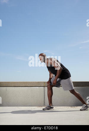 Longueur totale de droit de monter et de solides jeunes modèle masculin prêt pour son exécution. Athlète masculin musculaire à l'extérieur. Banque D'Images