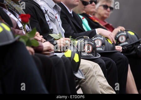 Ottawa, Canada. 14Th Sep 2014. Les membres de la famille des pompiers morts s'asseoir avec des roses et de cérémonie des casques au Canadian Memorial Monument commémoratif des pompiers à Ottawa, Canada, le 14 septembre, 2014. L'événement annuel attire des centaines de pompiers de partout au pays pour honorer leurs collègues disparus et voir leur nom ajouté à la désormais 1200 qui ornent le monument. Credit : Cole Burston/Xinhua/Alamy Live News Banque D'Images