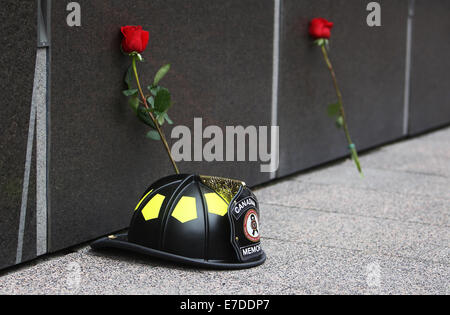 Ottawa, Canada. 14Th Sep 2014. Une cérémonie memorial casque et roses reste contre le mur commémoratif à l'pompier, à Ottawa, Canada, le 14 septembre, 2014. L'événement annuel attire des centaines de pompiers de partout au pays pour honorer leurs collègues disparus et voir leur nom ajouté à la désormais 1200 qui ornent le monument. Credit : Cole Burston/Xinhua/Alamy Live News Banque D'Images