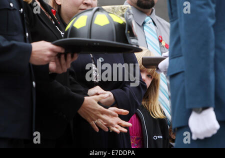 Ottawa, Canada. 14Th Sep 2014. Paige Baron, 7, petite-fille de la fin de chef adjoint des pompiers Antonius Lippers pairs au moyen d'un casque de cérémonie comme memorial est décerné à un membre de la famille à l'pompier, à Ottawa, Canada, le 14 septembre, 2014. L'événement annuel attire des centaines de pompiers de partout au pays pour honorer leurs collègues disparus et voir leur nom ajouté à la désormais 1200 qui ornent le monument. Credit : Cole Burston/Xinhua/Alamy Live News Banque D'Images