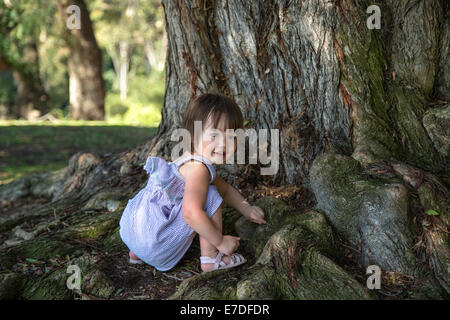 Bébé fille jouant sous un arbre, San Diego, Californie Banque D'Images