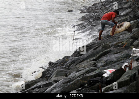 Manille, Philippines. 15 Sep, 2014. Un homme cherche des matériaux réutilisables, près de la baie de Manille à Manille, Philippines, le 15 septembre 2014. Le typhon Kalmaegi (nom local Luis) a fait un touché terre au nord des Philippines le dimanche après-midi et on s'attend à rester dans le pays jusqu'à mardi, l'État a déclaré l'agence météorologique. Credit : Rouelle Umali/Xinhua/Alamy Live News Banque D'Images