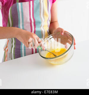 Fille de battre les oeufs dans un bol avec une fourchette Banque D'Images