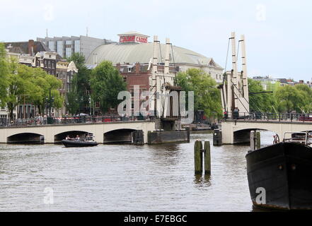 La célèbre Magere Brug enjambant la rivière Amstel dans le centre-ville d'Amsterdam, Pays-Bas, ouverte pour laisser passer un navire Banque D'Images