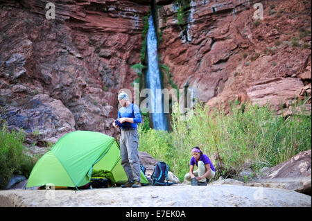 Les randonneurs setup campement sur une plage le long de la rivière Colorado, près de l'plumeting 180 pieds de Deer Creek Falls dans le Grand Canyon en dehors de Fredonia, Arizona Novembre 2011. Les 21,4 milles boucle démarre à la Bill Hall sur le sentier Rive Nord et descend, 2000 pieds de 2,5 milles à travers les grès de Coconino le niveau de l'Esplanada descend ensuite plus loin dans la partie inférieure de canyon à travers une pause au 400-foot-tall Redwall pour accéder à Vallée Surprise. Les randonneurs se connecter la rivière Thunder et Tapeats Creek à un itinéraire le long de la rivière Colorado et sortir Deer Creek. Banque D'Images