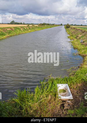 Drainage d'une digue dans le Lincolnshire Fens avec une vieille baignoire jetés, Banque D'Images