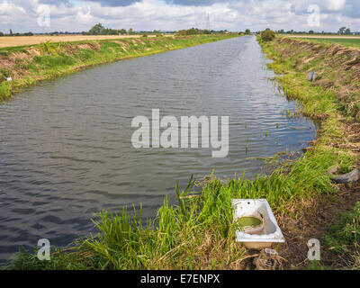 Drainage d'une digue dans le Lincolnshire Fens avec une vieille baignoire jetés, Banque D'Images