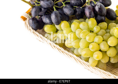 Les différentes variétés de raisins dans panier en osier isolé sur fond blanc Banque D'Images