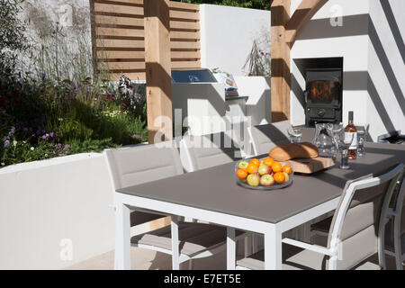 Jardin - Al Fresco - vue sur le jardin extérieur contemporain mobilier de salle à manger coin salon patio avec tables et chaises poêle à bois extérieur Royaume-Uni Banque D'Images