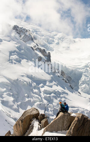 Le Mont Blanc et le glacier des Bossons depuis l'Aiguille du Midi, en France, avec les grimpeurs sur l'arête des Cosmiques. Banque D'Images