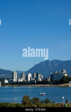 Un False Creek Ferry sur English Bay avec extrémité ouest des tours et les montagnes du North Shore de Vanier Park, Vancouver, British Columbia, Canada Banque D'Images