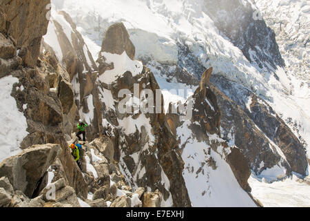 Le Mont Blanc et le glacier des Bossons depuis l'Aiguille du Midi, en France, avec les grimpeurs sur l'arête des Cosmiques. Banque D'Images