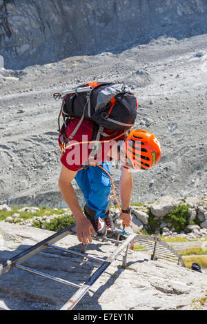 Les grimpeurs descendre des échelles menant vers le bas sur la mer de glace près de la gare du Montenvers. La ligne fut construite à l'époque victorienne pour prendre les touristes jusqu'au glacier, il a par la suite du 150 mètres depuis 1820, et se retira en 2300 mètres. Afin d'accéder au glacier vous avez maintenant de descendre plus de 100 mètres sur des échelles. Banque D'Images