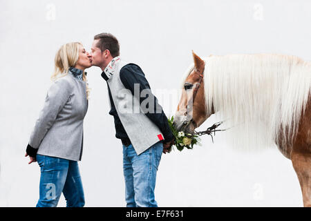 L'homme et la femme s'embrasser, manger Haflinger du Tyrol du Nord fleurs, Tyrol, Autriche Banque D'Images