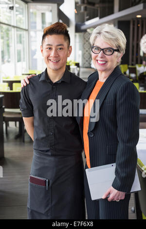 Businesswoman smiling in restaurant et de l'eau Banque D'Images