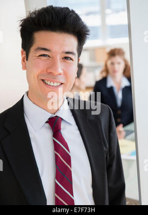 Mixed Race woman smiling in office Banque D'Images